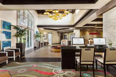 a lobby of a hotel with a table and chairs at Cape Rey Carlsbad Beach, A Hilton Resort & Spa in Carlsbad