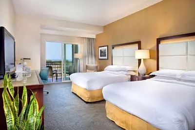 a hotel room with two beds and a balcony at Cape Rey Carlsbad Beach, A Hilton Resort & Spa in Carlsbad