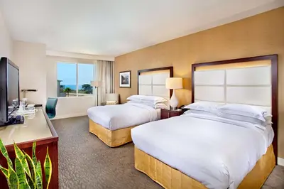 a hotel room with two beds and a television at Cape Rey Carlsbad Beach, A Hilton Resort & Spa in Carlsbad