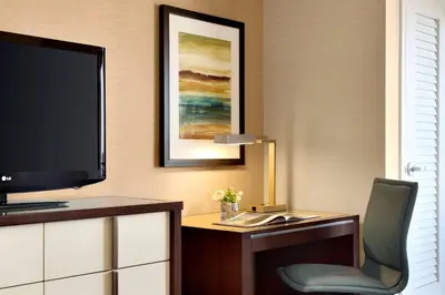 a room with a television and a desk with a chair at Cape Rey Carlsbad Beach, A Hilton Resort & Spa in Carlsbad