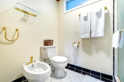 a white bathroom with a toilet and a sink at Sunny Dreams Home in San Diego