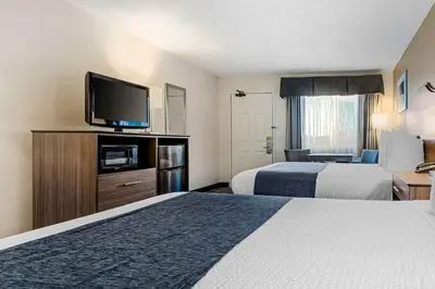 a hotel room with two beds and a flat screen tv at Best Western Santee Lodge in Santee