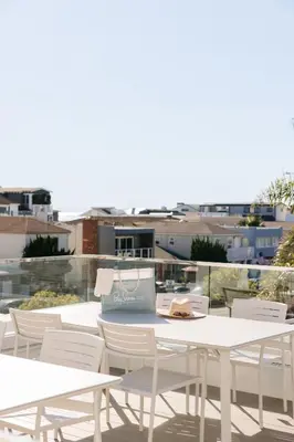 a group of tables and white chairs on a roof at Bay Shores Peninsula Hotel in Newport Beach