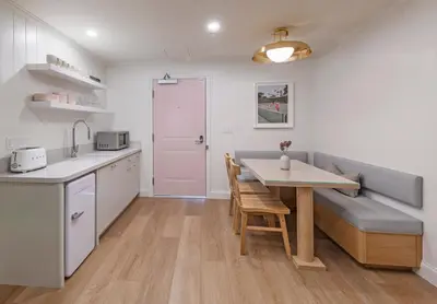 a kitchen and dining room with a table and a bench at Bay Shores Peninsula Hotel in Newport Beach