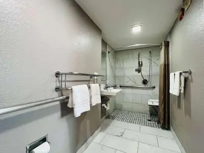 a bathroom with a shower and a sink with towels at Motel 6-La Mesa, CA - San Diego in La Mesa