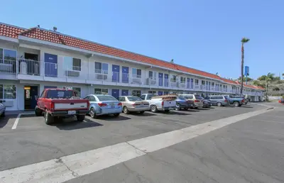 a row of cars parked in a parking lot in front of a building at Motel 6-La Mesa, CA - San Diego in La Mesa