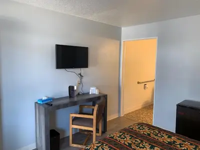 a hotel room with a desk with a bed and a television at EZ 8 Motel Old Town in San Diego