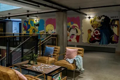 a room with chairs and a table and a mural at Moxy San Diego Gaslamp Quarter in San Diego