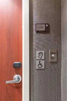 a door with a sign on it next to a handicapped sign at Courtyard by Marriott San Diego Oceanside in Oceanside