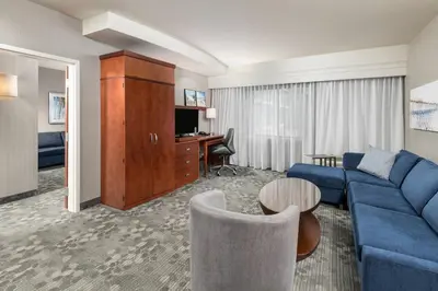 a living room with a blue couch and a desk at Courtyard by Marriott San Diego Oceanside in Oceanside