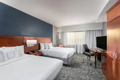 a hotel room with two beds and a desk at Courtyard by Marriott San Diego Oceanside in Oceanside