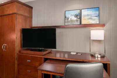 a room with a desk with a flat screen tv at Courtyard by Marriott San Diego Oceanside in Oceanside