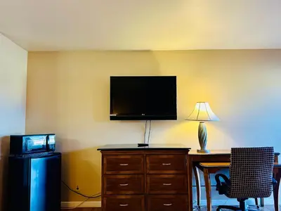 a room with a desk with a television and a desk sidx sidx sidx at Franciscan Inn Motel in Vista