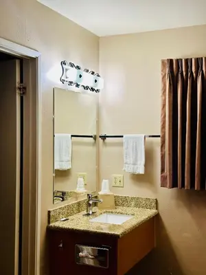 a bathroom with a sink and a mirror at Franciscan Inn Motel in Vista