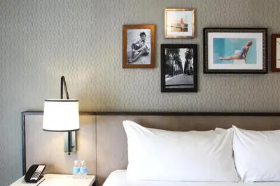 a bedroom with a bed with pictures on the wall at La Valencia Hotel in San Diego