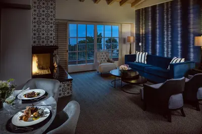 a living room with a couch and a fireplace at La Valencia Hotel in San Diego