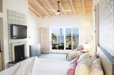 a living room with a couch and a fireplace at La Valencia Hotel in San Diego