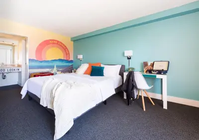 a bedroom with a large bed with a painting on the wall at Rambler Hotel in Chula Vista