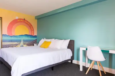 a bedroom with a bed and a wall with a mural at Rambler Hotel in Chula Vista