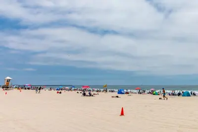 a crowd of people on a beach with umbrellas at Fantastic Mission Beach condo steps to the Beach in San Diego