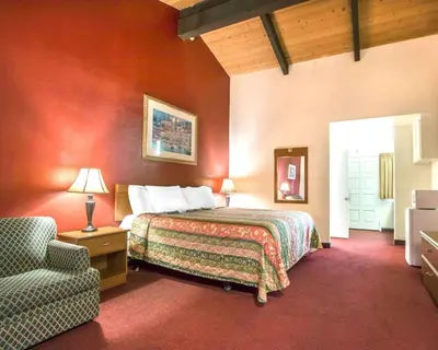 a hotel room with a bed and a chair at Rodeway Inn Fallbrook Downtown in Fallbrook