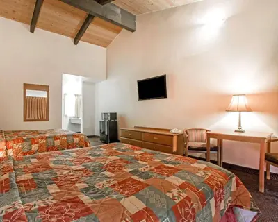 a hotel room with a bed and a desk and a television at Rodeway Inn Fallbrook Downtown in Fallbrook