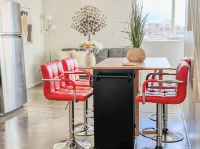 a kitchen with red bar stools and a table at Little Italy Modern Lofts in San Diego