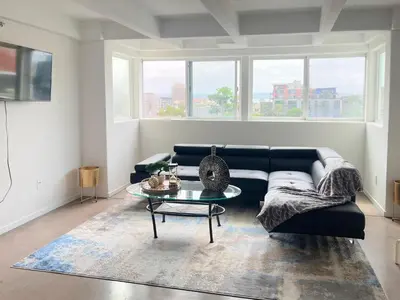 a living room with a black couch and a table at Little Italy Modern Lofts in San Diego