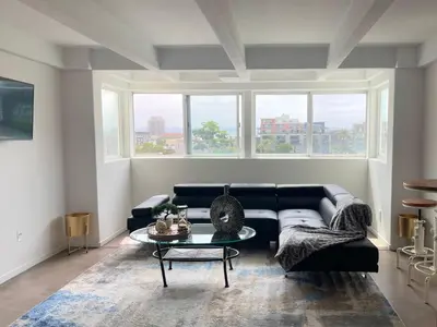 a living room with a black couch and a table at Little Italy Modern Lofts in San Diego