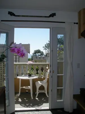 an open door to a patio with a table and chairs at Secret Garden Inn in San Diego