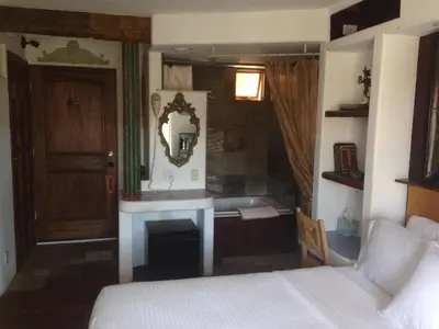 a bedroom with a bed and a bathroom with a tub at Secret Garden Inn in San Diego