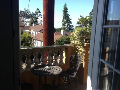 a balcony with two chairs and a window at Secret Garden Inn in San Diego