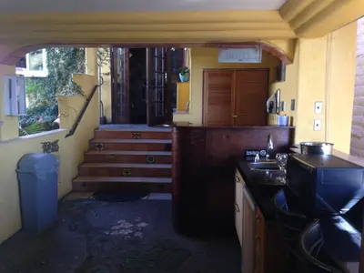 a kitchen with a sink and a stairway at Secret Garden Inn in San Diego