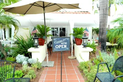 a sign on a patio with an umbrella and plants at Crown City Inn Coronado in San Diego