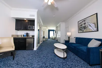 a living room with a blue couch and a kitchen at Horton Grand Hotel in San Diego
