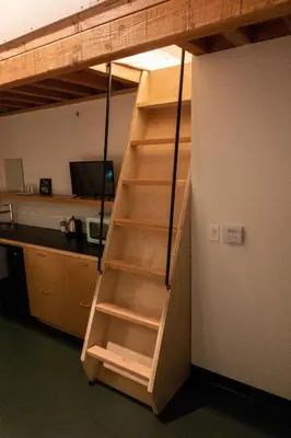 a ladder to a loft bed in a room at Abpopa Hillcrest in San Diego