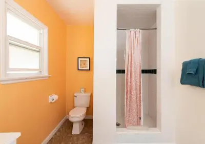 a bathroom with a toilet and a window at The Patriots Boutique Motel in San Clemente