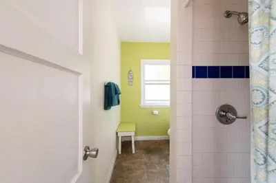 a bathroom with a shower with a toilet and a window at The Patriots Boutique Motel in San Clemente