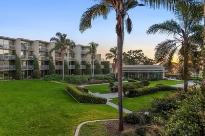 an exterior view of the resort with palm trees at Hilton La Jolla Torrey Pines in San Diego