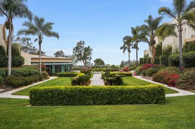 a garden with palm trees and a building at Hilton La Jolla Torrey Pines in San Diego