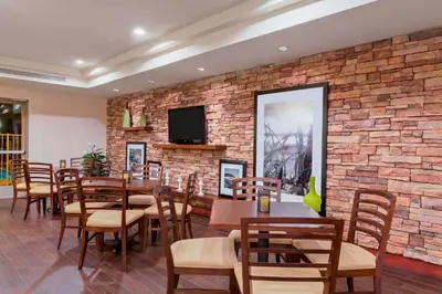 a restaurant with tables and chairs and a brick wall at Hampton Inn San Marcos in San Marcos