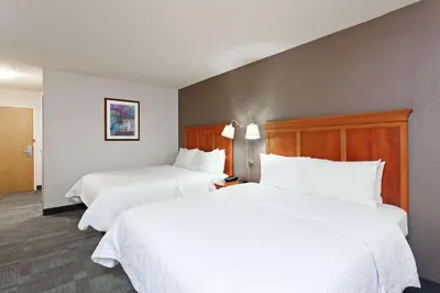 two beds in a hotel room with white sheets at Hampton Inn San Marcos in San Marcos