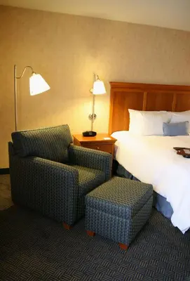 a hotel room with a bed and a chair at Hampton Inn San Marcos in San Marcos