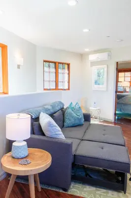 a living room with a blue couch and a table at The Little Pumpkin Guest House in San Diego