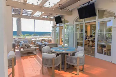 a restaurant with a table and chairs and a television at Hilton Garden Inn Carlsbad Beach in Carlsbad