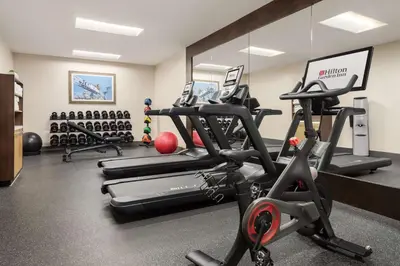 a gym with several treadmills and exercise bikes at Hilton Garden Inn Carlsbad Beach in Carlsbad
