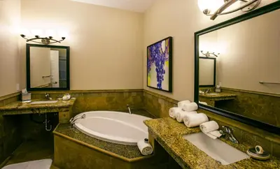 a bathroom with a tub and a large mirror at South Coast Winery Resort & Spa in Temecula