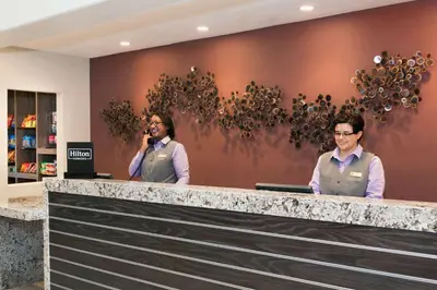two men standing at a counter in a store at Embassy Suites by Hilton Temecula Valley Wine Country in Temecula