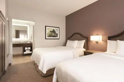a hotel room with two beds and a mirror at Embassy Suites by Hilton Temecula Valley Wine Country in Temecula