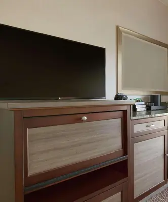 a large flat screen tv on a wooden entertainment center at Embassy Suites by Hilton Temecula Valley Wine Country in Temecula